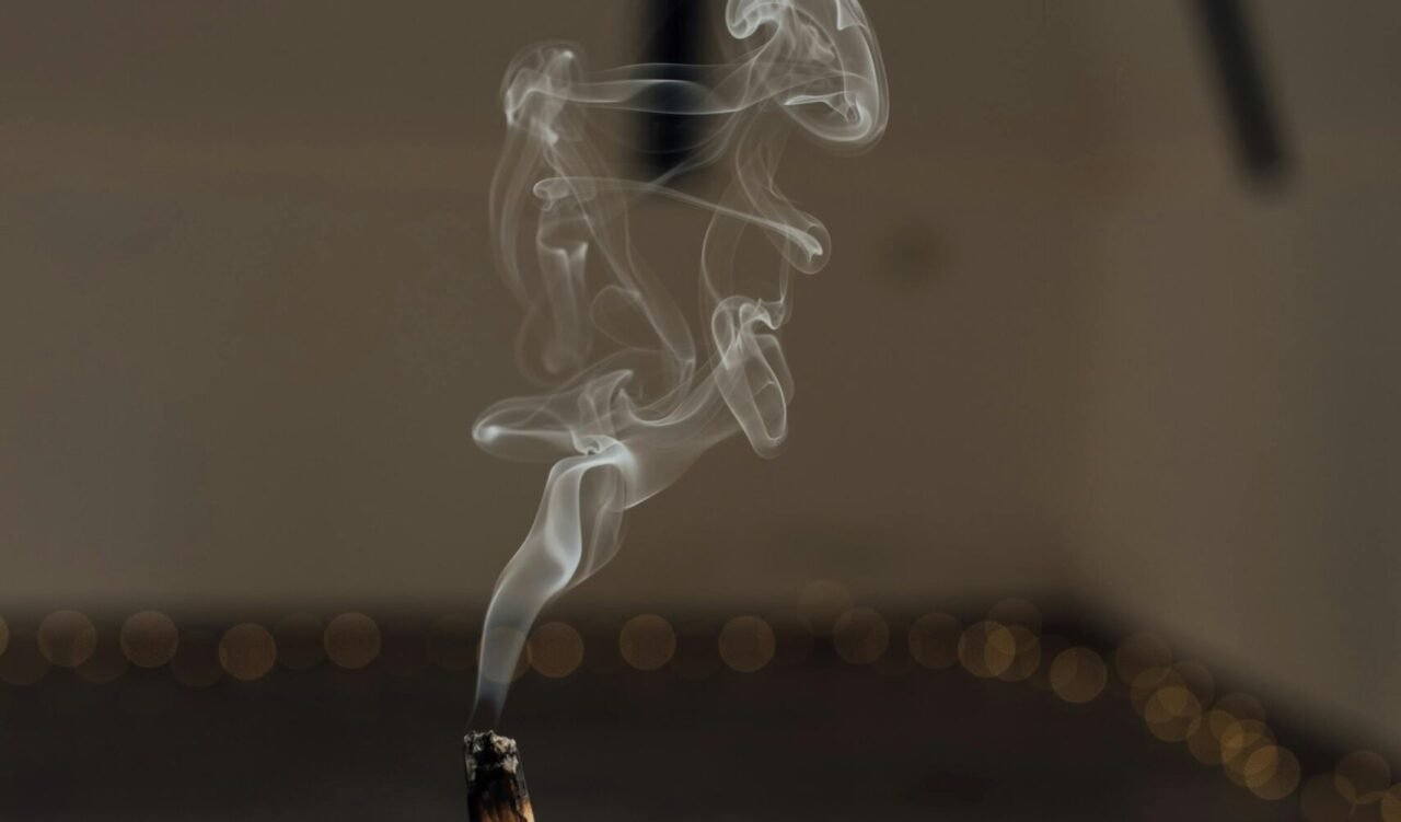 Petit morceau de bois enflammé, dégageant une flamme douce et une lueur chaleureuse.