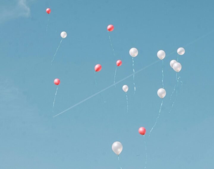 Des ballons s’envolant dans le ciel, symbole de lâcher-prise et de liberté.