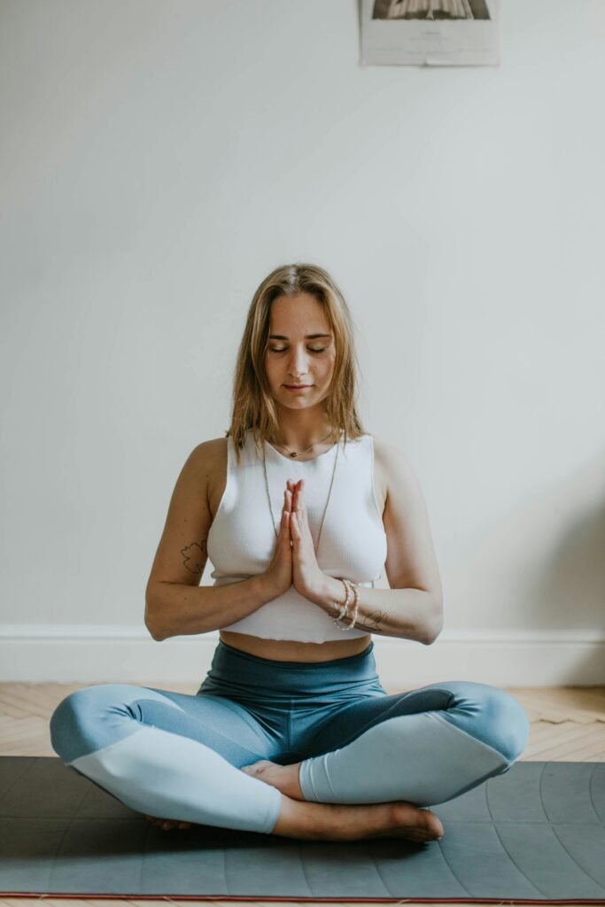 Femme en position de méditation (lotus), yeux fermés, inspirant la paix intérieure.