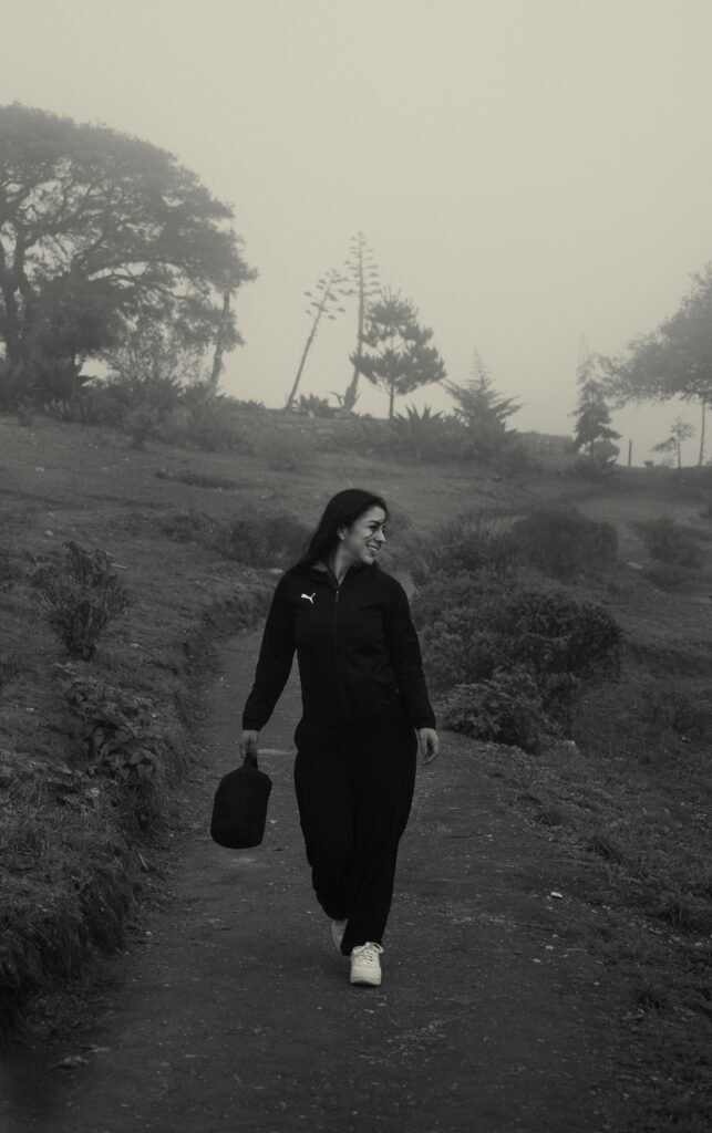 Une femme marche seule sur un sentier calme, en pleine nature.